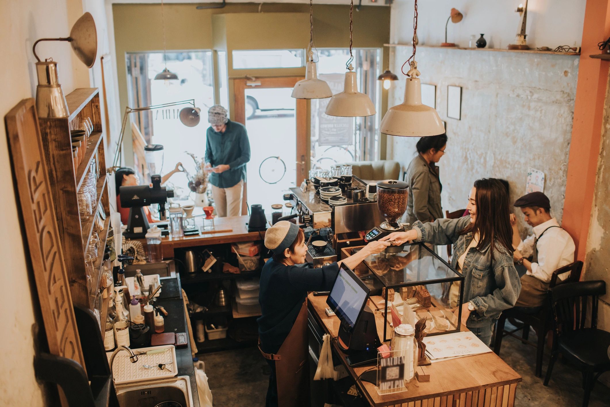 Barista welcoming a customer at the cafe counter