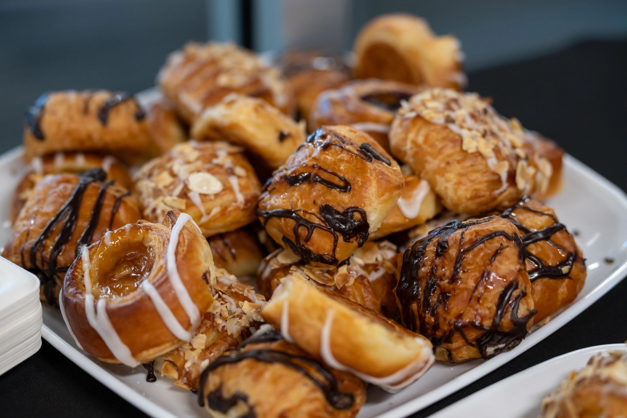Pastries drizzled with chocolate and topped with almonds