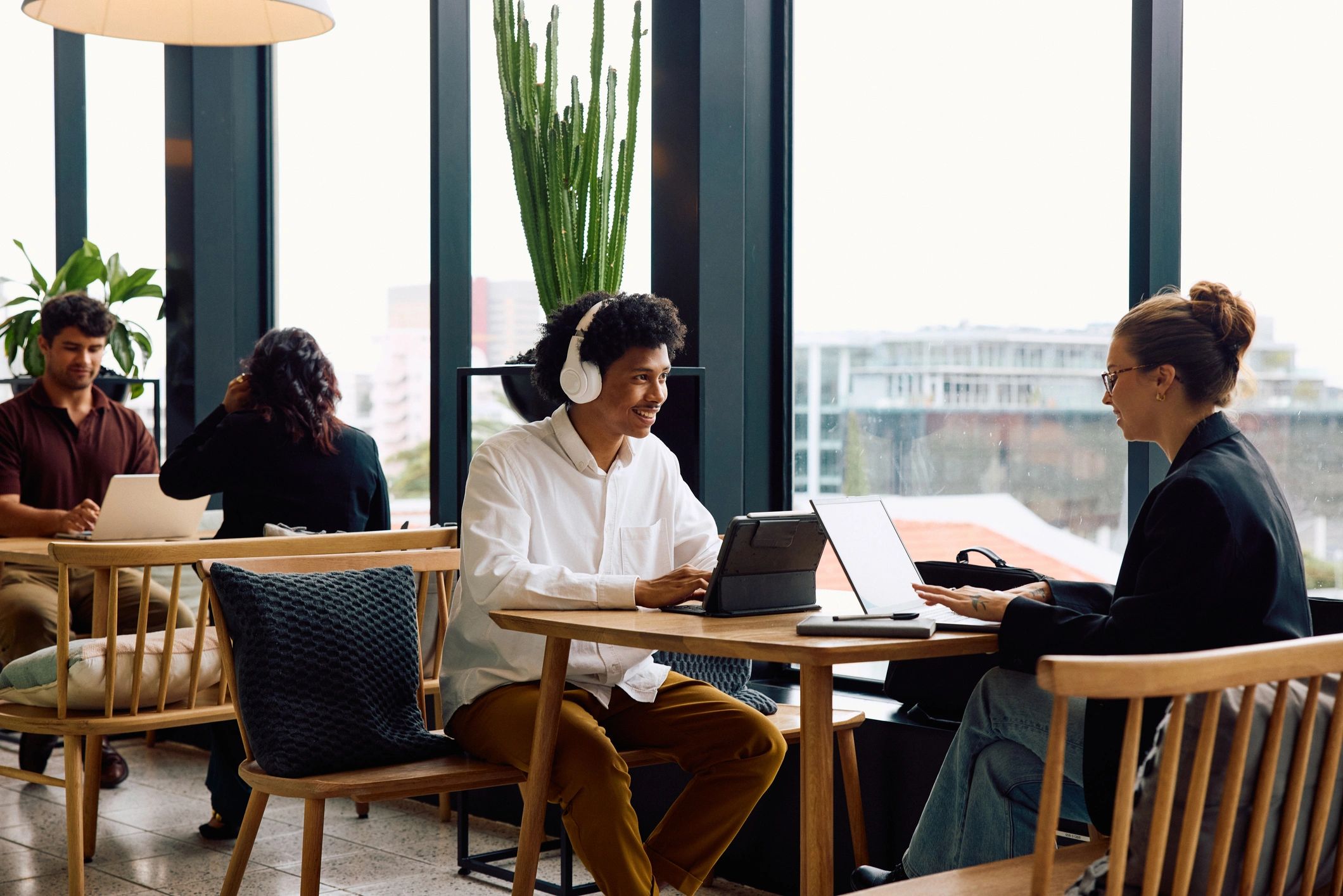 People working with laptops in a bright cafe-like space.