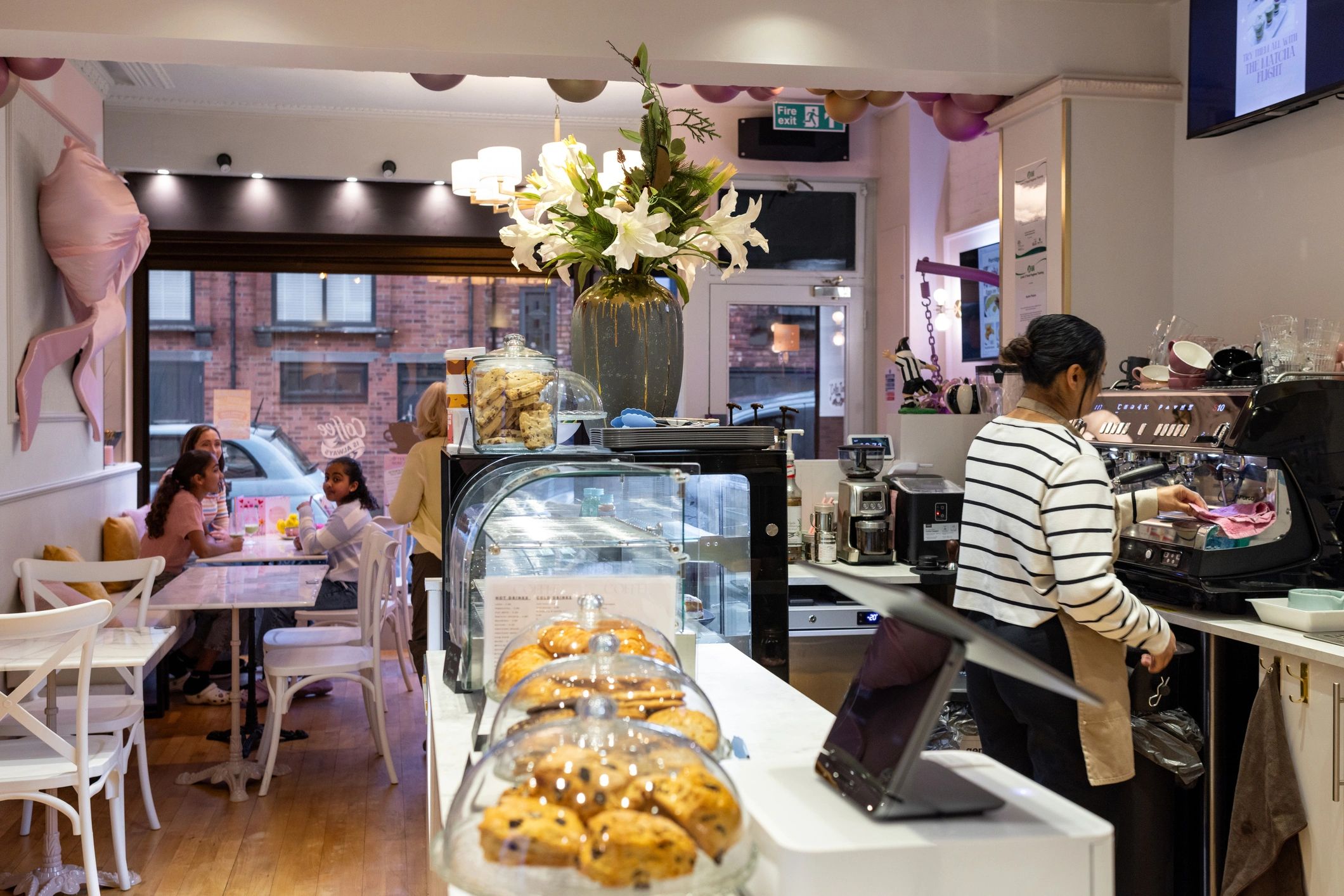 Bright, modern cafe interior with customers and barista at the espresso bar